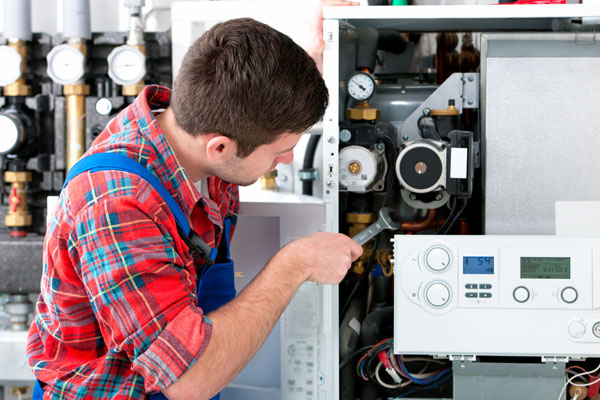 Heating technician repairing boiler controls in Santa Paula