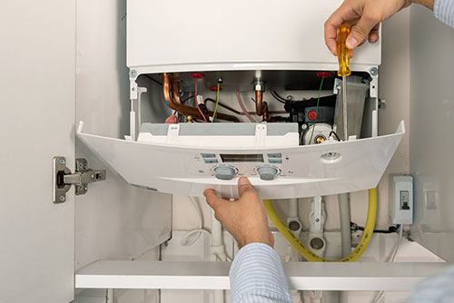 Heating technician repairing a residential boiler in Santa Paula
