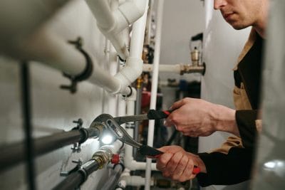 Technician inspecting commercial plumbing pipes in Santa Paula