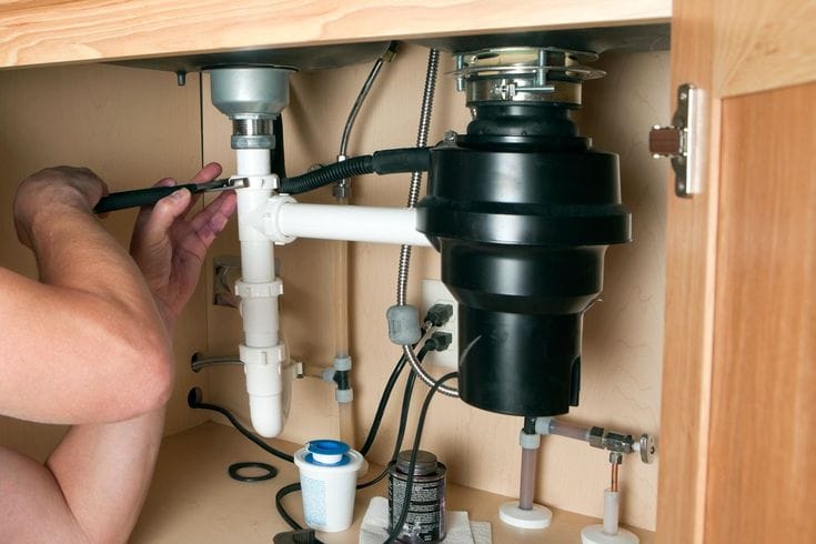 Plumber repairing a garbage disposal in Santa Paula