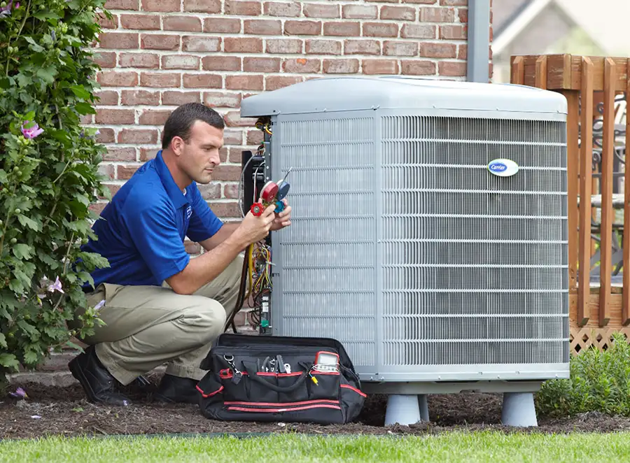 HVAC technician inspecting an outdoor AC unit in Santa Paula