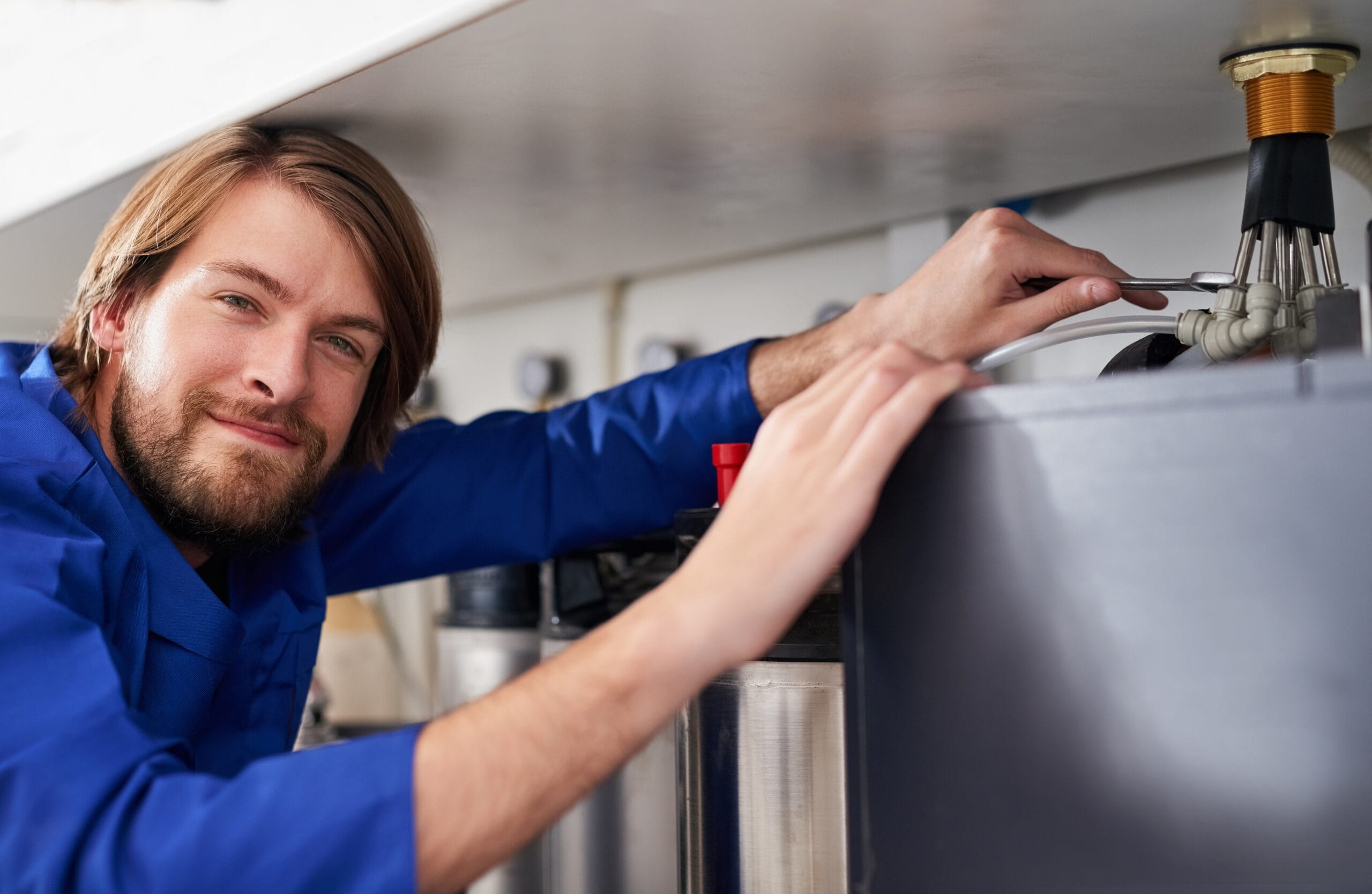 Technician servicing a residential water heater tank in Santa Paula